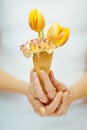 Woman hands holding spring flowers in an ice cream cone, sensual studio shot Royalty Free Stock Photo