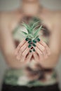 Woman hands holding succulent plant, with perfect green nail polish