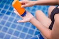 Woman hands holding sunscreen cream,Female using sunblock at swimming pool,Summer travel concept Royalty Free Stock Photo