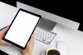 Woman hands holding tablet computer with isolated screen and cup of coffee. Business workplace with computer and wireless mouse an Royalty Free Stock Photo