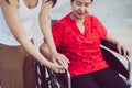 Woman hands holding to asian mature sitting on wheelchair,Take care and suport,Senior insurance concept