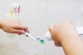 Woman hands is holding toothbrush and placing toothpaste on it. Royalty Free Stock Photo