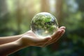 Woman hands holding transparent earth globe over blurred background. Generative AI Royalty Free Stock Photo