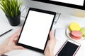 Woman hands holding and using tablet computer with white screen. Business workplace with computer and wireless mouse Royalty Free Stock Photo