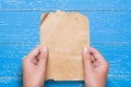 Woman hands holding vintage paper sheet over aged blue wooden ta Royalty Free Stock Photo