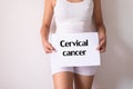 Woman hands holding a white sign with the word cervical cancer disease on white background