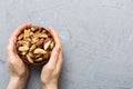 Woman hands holding a wooden bowl with brazil or bertholletia nuts. Healthy food and snack. Vegetarian snacks of Royalty Free Stock Photo