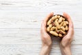 Woman hands holding a wooden bowl with close peanuts. Healthy food and snack. Vegetarian snacks of different nuts Royalty Free Stock Photo