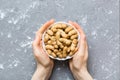 Woman hands holding a wooden bowl with close peanuts. Healthy food and snack. Vegetarian snacks of different nuts Royalty Free Stock Photo