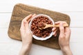 Woman hands holding a wooden bowl with peanuts. Healthy food and snack. Vegetarian snacks of different nuts Royalty Free Stock Photo