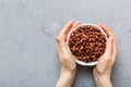 Woman hands holding a wooden bowl with peanuts. Healthy food and snack. Vegetarian snacks of different nuts Royalty Free Stock Photo