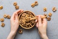 Woman hands holding a wooden bowl with walnut nuts. Healthy food and snack. Vegetarian snacks of different nuts Royalty Free Stock Photo