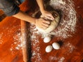 Woman hands kneading flour on wooden table