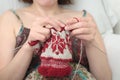 Woman hands knitting snowflake pattern