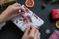 Woman hands make bow on present on the black table.