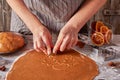 Woman hands make cookies shapes from rolled gingerbread dough