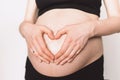 Woman hands making heart on pregnant belly. Pregnancy, maternity, preparation, baby expectation concept Royalty Free Stock Photo