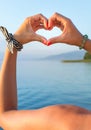 Woman hands making heart shape at the beach Royalty Free Stock Photo