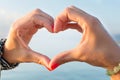 Woman hands making heart shape at the beach Royalty Free Stock Photo