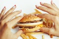 Woman hands with manicure holding hamburger and Royalty Free Stock Photo