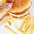 Woman hands with manicure holding hamburger and Royalty Free Stock Photo