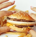 Woman hands with manicure holding hamburger and french fries isolated on white, food unhealthy Royalty Free Stock Photo