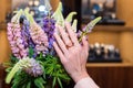 Woman hands with manicure and luxury jewelry rings. Close up of female hand on flowers showing fashion jewelry at camera Royalty Free Stock Photo