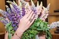 Woman hands with manicure and luxury jewelry rings. Close up of female hand on flowers showing fashion jewelry at camera Royalty Free Stock Photo