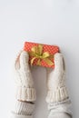 Woman hands in mittens holding red gift box isolated on white background. Top view, flat lay. Copyspace. Royalty Free Stock Photo