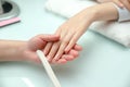 Woman hands in a nail salon receiving a manicure. Nail filing. Close up Royalty Free Stock Photo