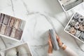 Woman hands neatly folding underwears and sorting in drawer organizers on white marble background.