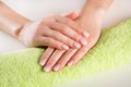 Woman hands with ombre french nails manicure on green towel Royalty Free Stock Photo