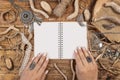 Woman hands on opened textbook between bohemian decorations