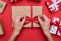 Woman hands packing gift box isolated over red flat layout Royalty Free Stock Photo