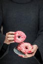 Woman hands with perfect nail polish holding a plate with pink donuts Royalty Free Stock Photo