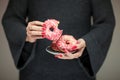 Woman hands with perfect nail polish holding a plate with pink donuts Royalty Free Stock Photo