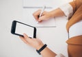 Woman, hands and phone writing on mockup above for schedule planning, diary or notebook on table. Hand of female with