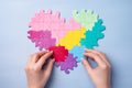 Woman hands piecing heart shaped puzzle. Valentine's Day, love search concept.