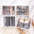 Woman hands placing organizer drawer divider with full of folded underwears and socks.