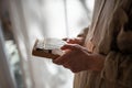 Woman hands studying to play music on wooden kalimba standing near window at home.