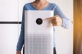 Women hands pointing to screen of white modern air purifier in a living room for refresh air flow at home,Advanced air purifying a