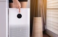 Woman hands pointing to screen of white modern air purifier in a living room for refresh air flow at home,Advanced air purifying a