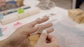 Woman hands in pottery studio using pottery sponge creating figurine of heart