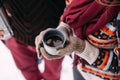 Woman hands pours hot tea or coffee out of thermos on winter forest background. girl using a thermos in on a snowy day. metallic c Royalty Free Stock Photo