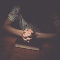 Woman hands praying with a bible, vintage tone