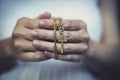 Woman hands praying holding a beads rosary with Jesus Christ in the cross or Crucifix on black background Royalty Free Stock Photo