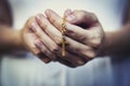 Woman hands praying holding a beads rosary with Jesus Christ in the cross or Crucifix on black background Royalty Free Stock Photo