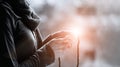 Woman hands praying and holding a beads rosary on lighting backgrouns, black&white, religious faith concept Royalty Free Stock Photo