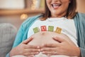 Woman, hands or pregnant stomach with baby building blocks, toys or wooden object in house or family home living room