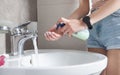 Woman hands pushing pump plastic soap bottle. Washing hands